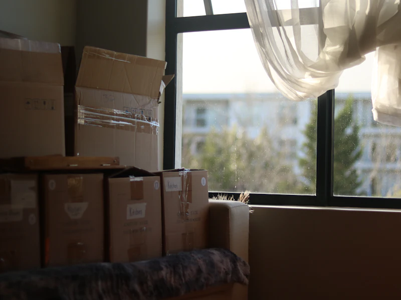 Gestapelte Umzugskartons am Fenster einer Wohnung